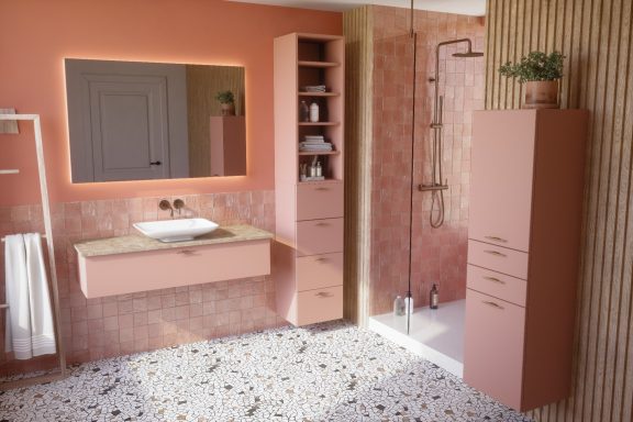 Salle de bain moderne avec murs roses, meuble suspendu et douche vitrée.